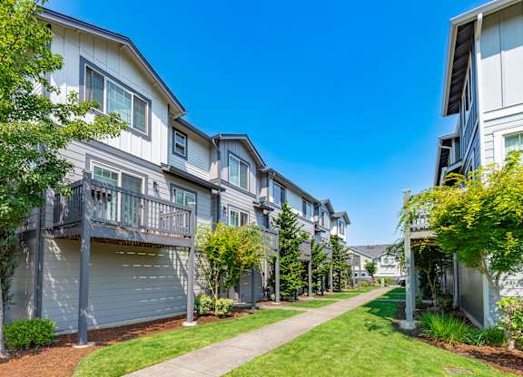 a row of houses with a sidewalk in front of them
