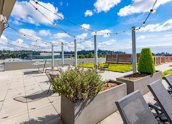 A patio with a table and chairs and a planter box.