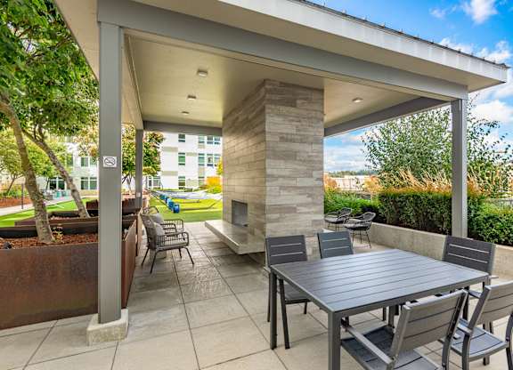 A patio with a table and chairs under a roof.