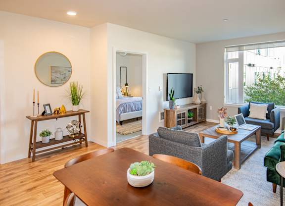 A living room with a wooden table and a green couch.