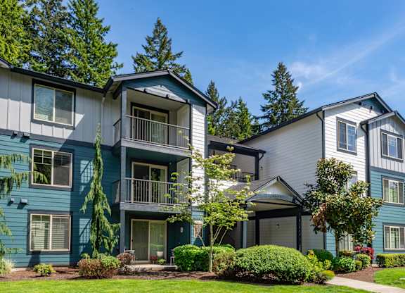 A row of townhouses with green trees in the background.