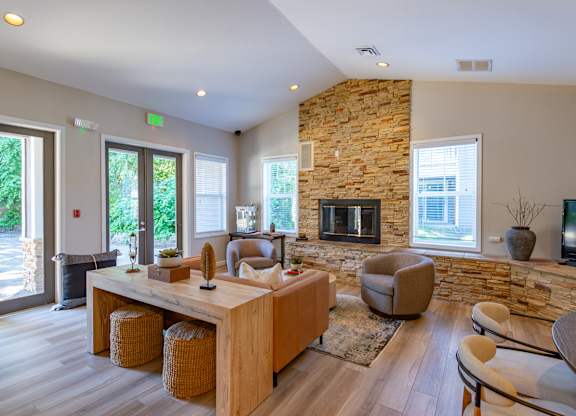 A living room with a stone fireplace and a wooden coffee table.