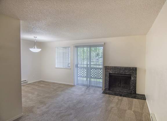 a living room with a fireplace and a patio door