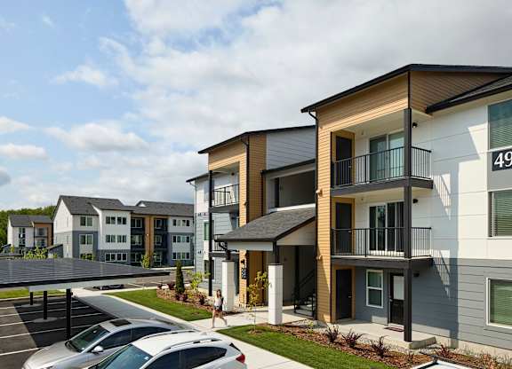 a rendering of a row of townhomes with cars parked in a parking lot