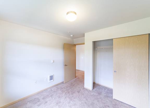 a bedroom with white walls and carpet