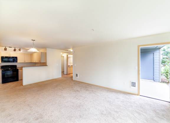 a large living room with a kitchen in the background