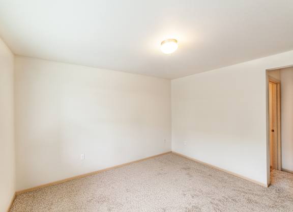 a bedroom with white walls and carpet