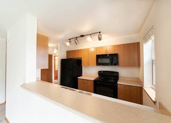 a kitchen with wood cabinets and black appliances