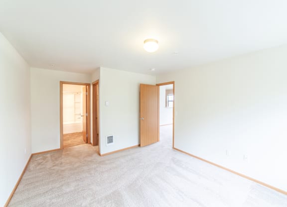 a bedroom with white walls and white carpet