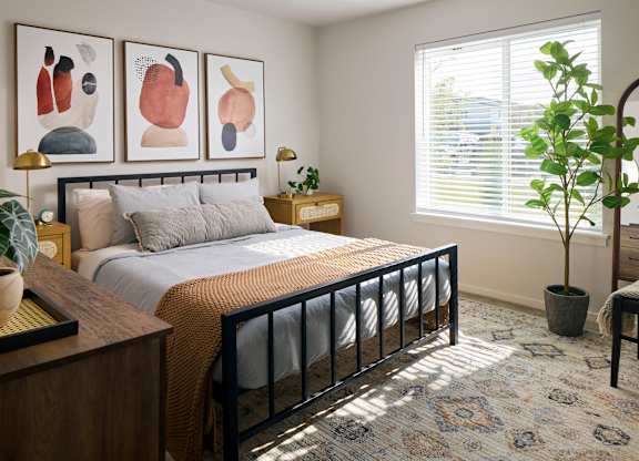 a bedroom with a large bed and two paintings on the wall