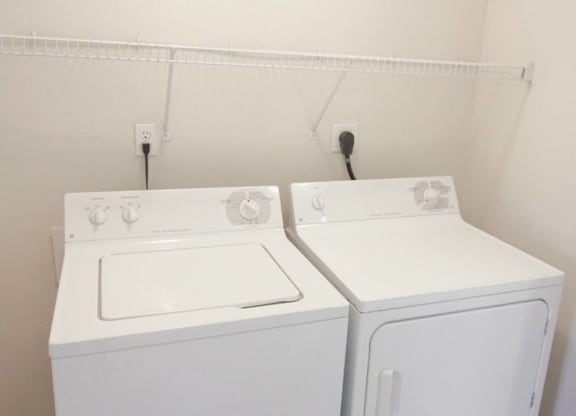 a white washer and dryer in a room with white walls