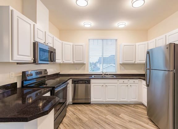 a kitchen with stainless steel appliances and white cabinets