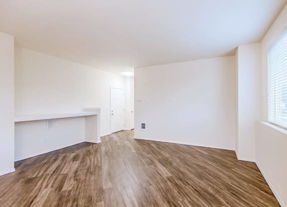 an empty living room with white walls and wood flooring