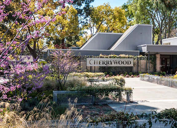Cherrywood sign in front of a building with trees and bushes at Cherrywood Apartments, San Jose, CA, 95118