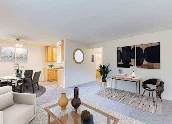A living room with a white couch, a coffee table, and a painting on the wall at Cherrywood Apartments, San Jose, California