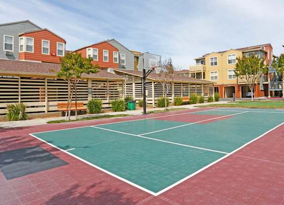 A tennis court is surrounded by apartment buildings at The Woods Apartments, California, 95136