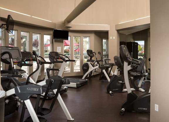 A gym with treadmills and elliptical machines at The Woods Apartments, San Jose, CA, 95136