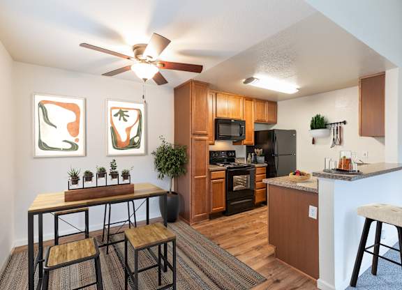 A kitchen with a table and chairs and a ceiling fan.