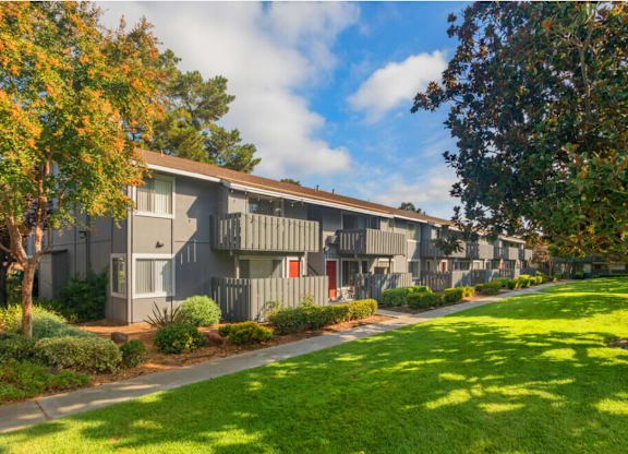 Apartment complex with green grass and trees in front at Cherrywood Apartments, San Jose, CA, 95118
