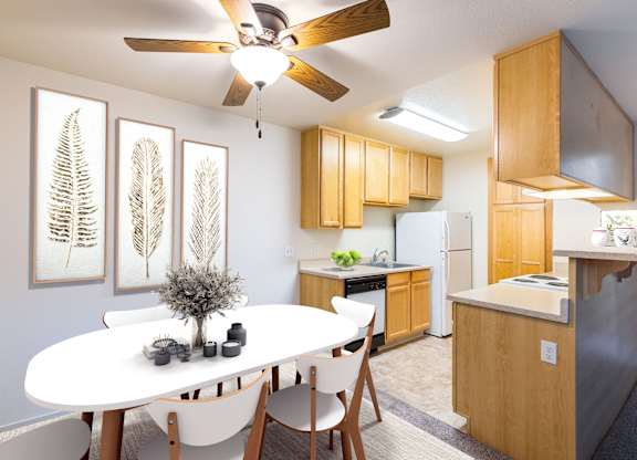 A white dining table with four chairs and a ceiling fan in a kitchen at The Woods Apartments, California, 95136