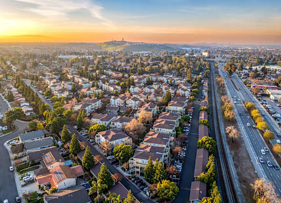 A sunset view of a city with a highway running through it at The Woods Apartments, California