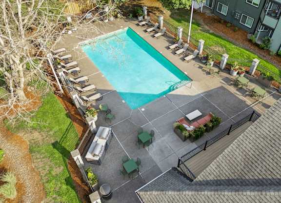 An aerial view of a pool surrounded by lounge chairs and umbrellas.