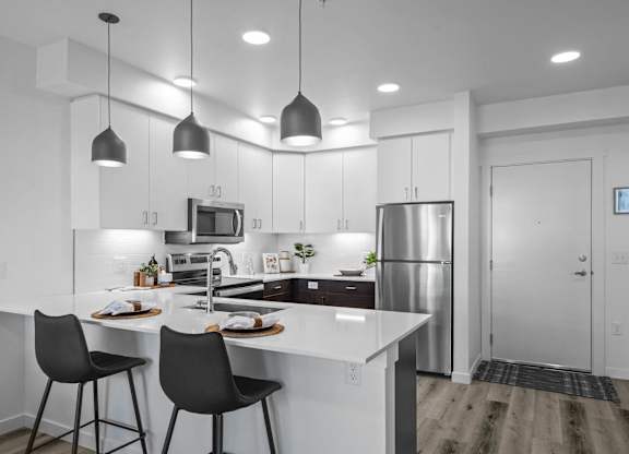an open kitchen with white cabinets and a white counter top