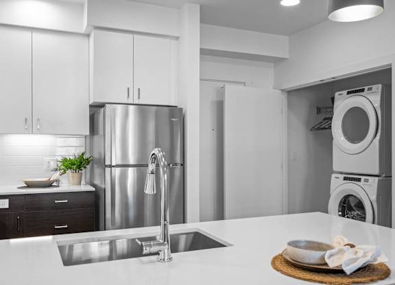 a white kitchen with a sink and a washing machine