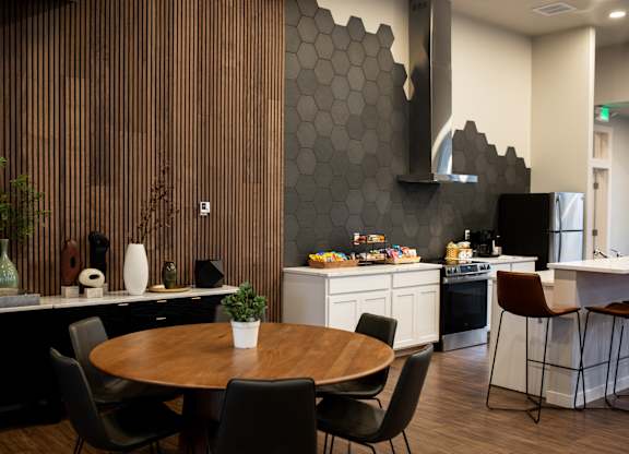 A modern kitchen with a wooden table and chairs.