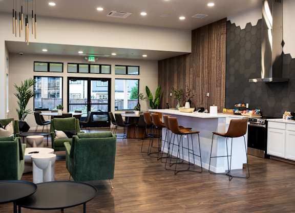 A modern living room with a kitchen area in the background.