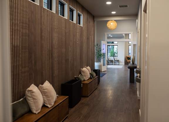 A long hallway with a bench and pillows on it.