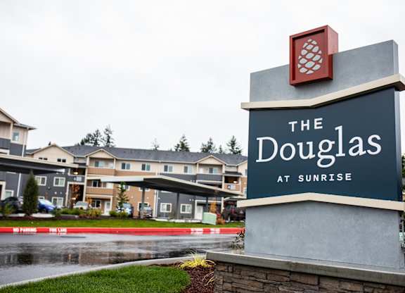 The sign for The Douglas at Sunrise is in front of a building.