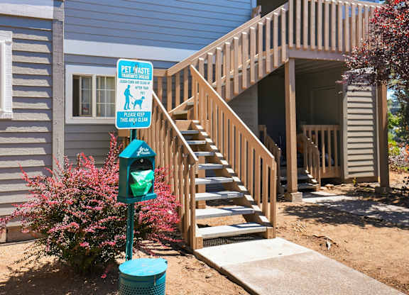 A sign on a pole that says "Pet Vast" is in front of a staircase.
