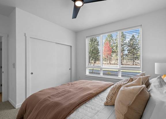 a bedroom with a large window and a bed