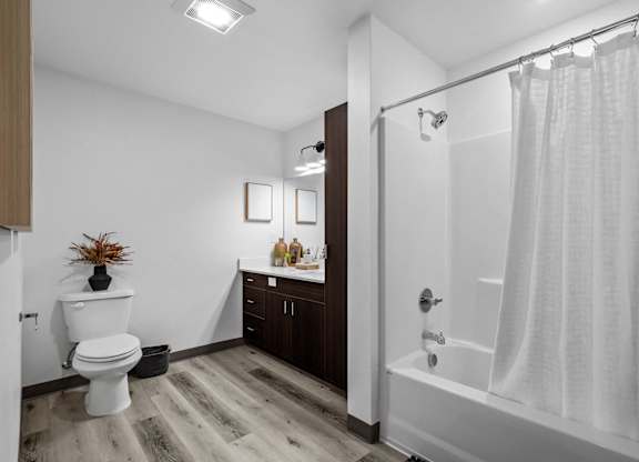 a bathroom with a shower and a toilet and a sink