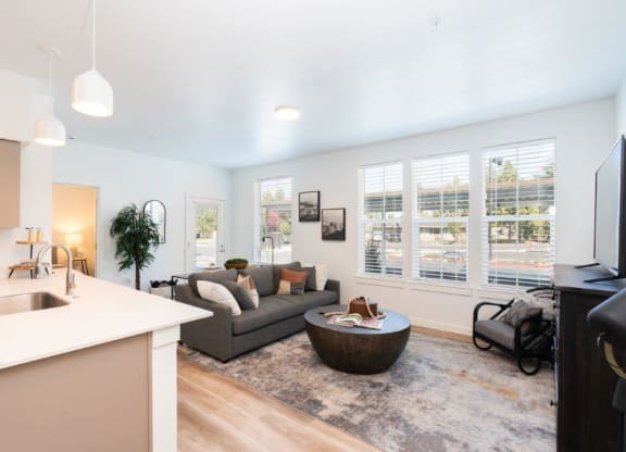 a living room and kitchen with a couch and a table