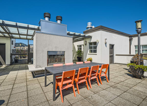a dining table and chairs on a patio with a fireplace