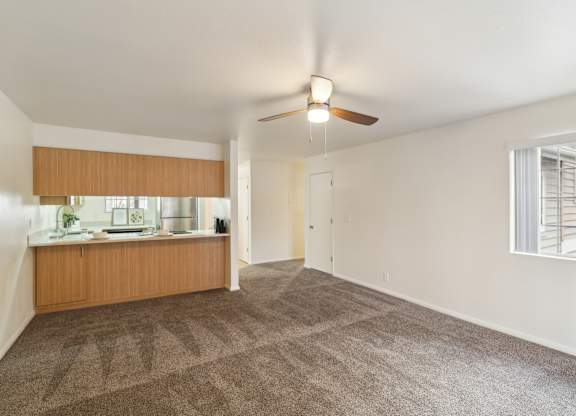 A room with a ceiling fan and carpeted floor.