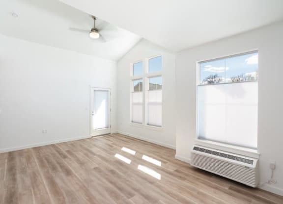an empty living room with a radiator and a window