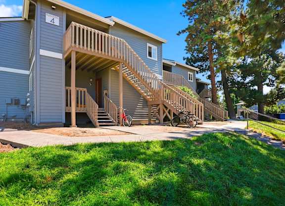A house with a wooden deck and stairs leading to the front door.