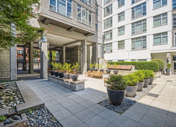 a courtyard with potted plants in front of a building