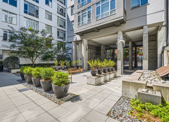 a courtyard with potted plants in front of a building