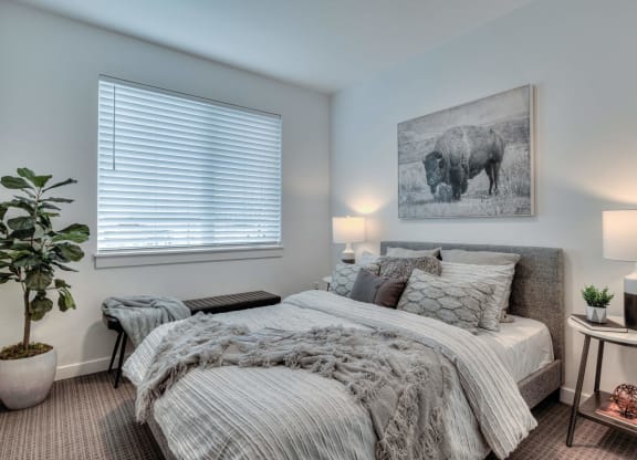 a bedroom with a bed and a painting of a cow