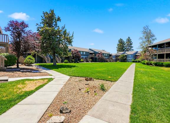 A residential area with a sidewalk and grassy areas.