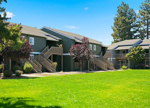 A row of houses with green lawns in front.