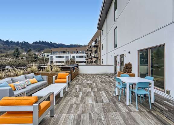 A patio with a table and chairs overlooking a building.