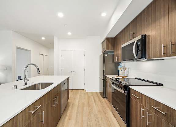 A modern kitchen with wooden cabinets and stainless steel appliances.