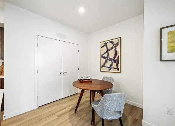 A dining room with a wooden table and chairs.