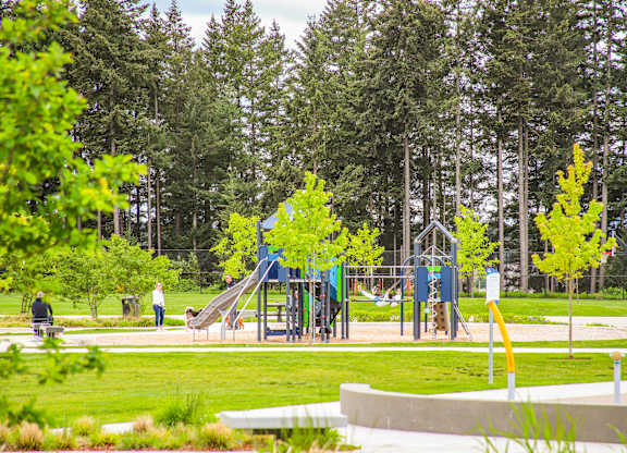 A playground with a blue slide and a yellow pole.