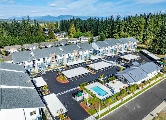 A large building complex with a pool in the middle.